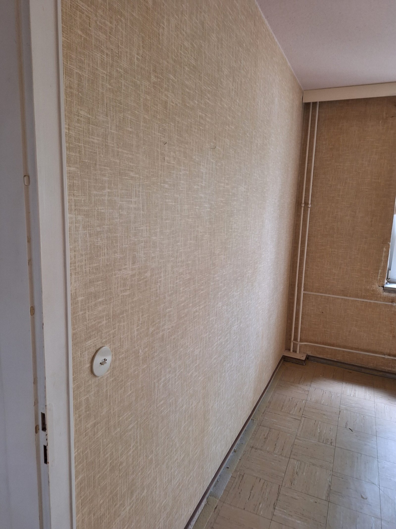 Wohnraum mit älteren Wand- und Bodenoberflächen vor der Modernisierung